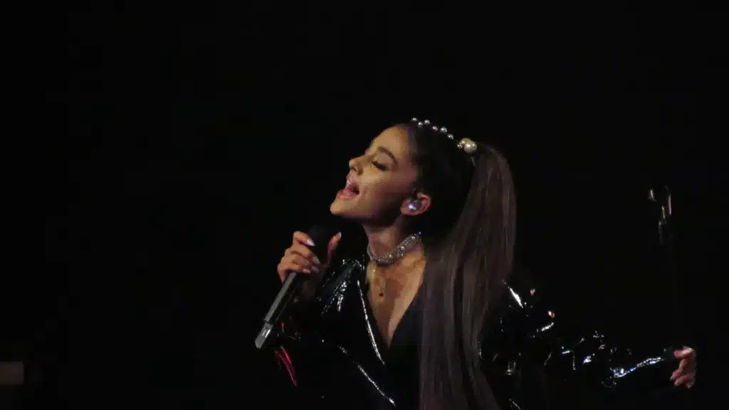Ariana Grande performing on stage during a concert, used for 2026 net worth analysis