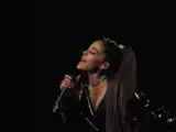 Ariana Grande performing on stage during a concert, used for 2026 net worth analysis